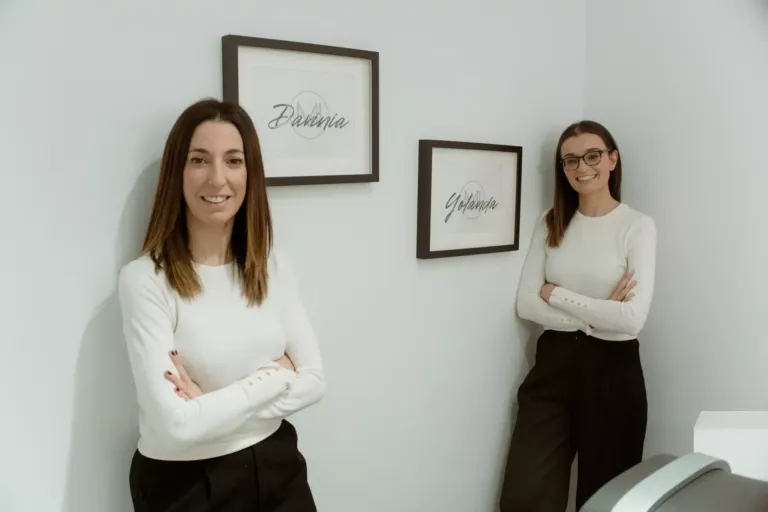Davinia y Yolanda posando junto a dos cuadros con sus nombres