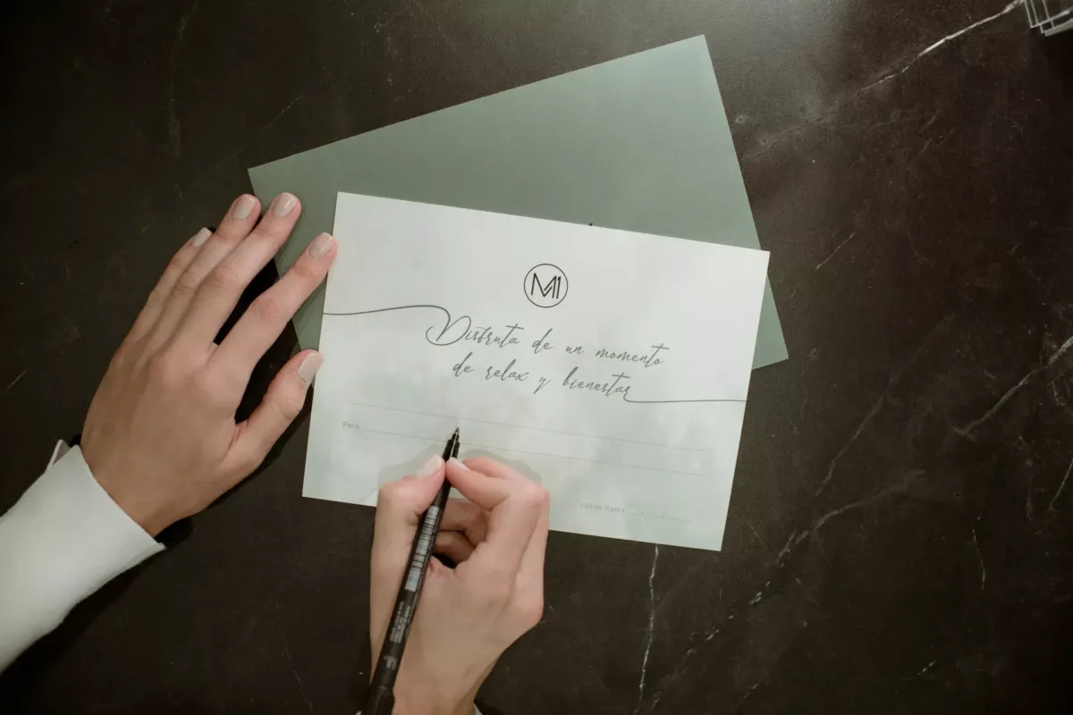 Primer plano de una mano escribiendo una tarjeta regalo